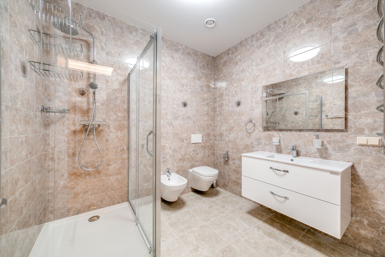 gallery-2 Contemporary bathroom featuring a glass shower and sleek fixtures in a minimalist design.